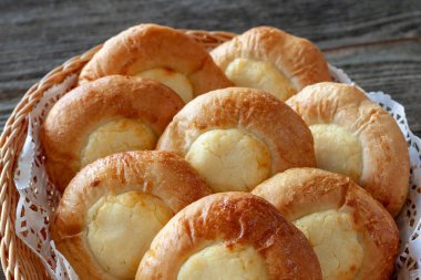 Ahşap bir masa üzerinde bir hasır sepet patates dolması cheesecakes.