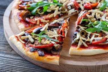 Vejetaryen yemek. Soya peyniri, mantar, domates, zeytin ve roka vejetaryen pizza. Sağlıklı gıda.