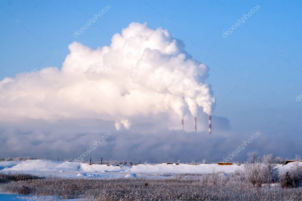 Pipes of thermal power plants emit thick smoke. Thermal power plants in thick fog. Probable air pollution.