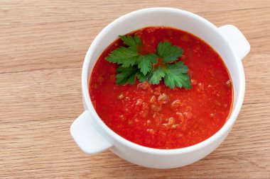 Vejetaryen yemek. Domates-mercimek çorbası, otlar ile dekore edilmiştir. Malzemeler: domates, kendi suyu, mercimek, soğan, baharat.