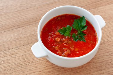 Vejetaryen yemek. Domates-mercimek çorbası, otlar ile dekore edilmiştir. Malzemeler: domates, kendi suyu, mercimek, soğan, baharat.