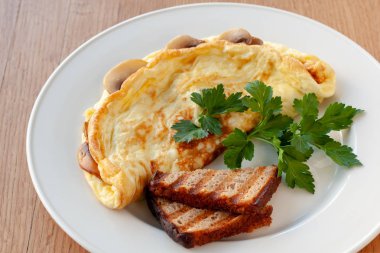 Vejetaryen yemek. Otlar ve tost ile dekore edilmiş mantarlı omlet.