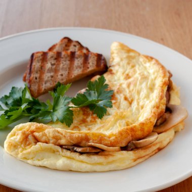 Vejetaryen yemek. Otlar ve tost ile dekore edilmiş mantarlı omlet. Kare biçimi.