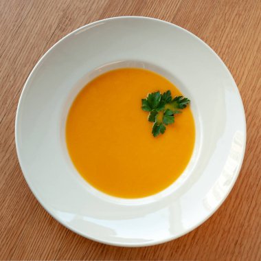 Vejetaryen yemek. Balkabağı çorbası ile köri, otlar ile dekore edilmiştir. Kare biçimi. Üstten Görünüm.