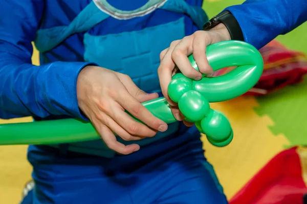 Clown makes figures from balloons.