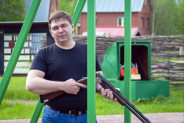 A man with a sports rifle at the shooting range.