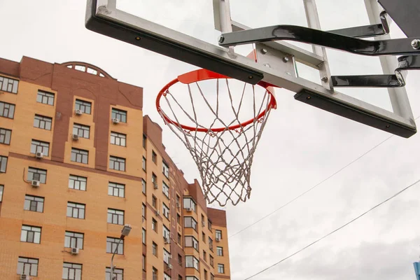 Basketball basket on the background of city houses. Street baske