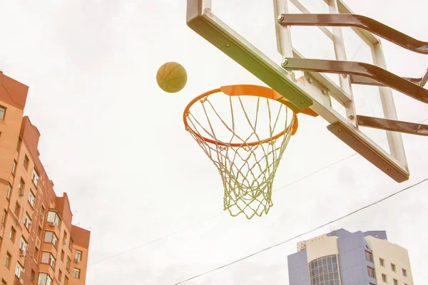 Basketball basket on the background of city houses. Street baske