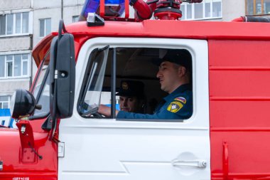 İtfaiye aracının itfaiyecileri, şehir festivalinde yangın güvenliğini sağlamak için hizmet veriyor.