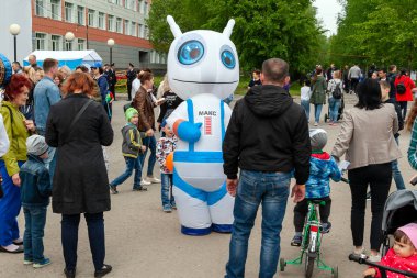Bir robot şeklinde bir yaşam boyutu bebek, bir tatilde çocuklar ve yetişkinler eğlendirir.