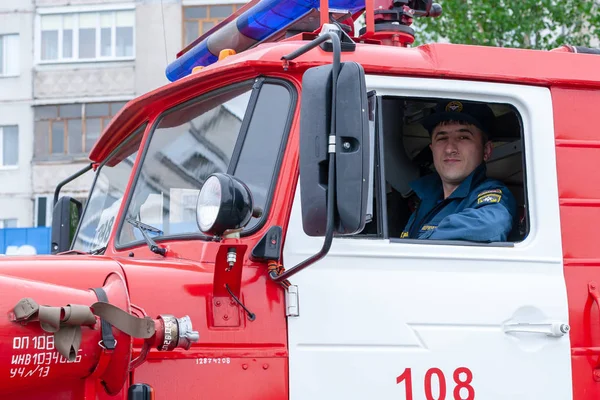 Feuerwehrleute auf dem Feuerwehrauto sorgen für den Brandschutz beim Stadtfest. — Stockfoto