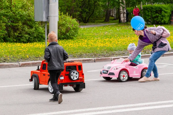 祭りでは、子供たちは大きなおもちゃの車に乗ります. — ストック写真