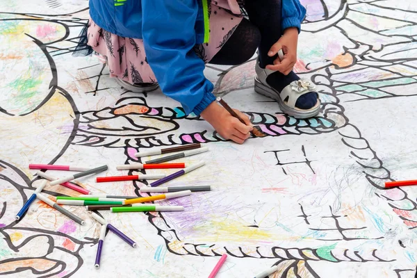 Çocuklar renkli işaretlerle yere çizerler. Festivalde çocukların aktif eğlencesi.