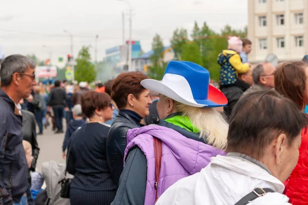 Une femme au festival dans un chapeau de cow-boy, peint dans le tricolore du drapeau russe . — Photo