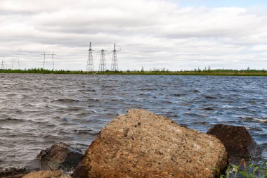 Öğlen yüksek gerilim li elektrik hatlarına sahip teknik tank.
