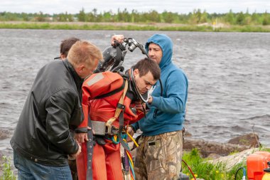 Destek ekibi, dalgıcın derin deniz çalışmalarına hazırlanmasına yardımcı olur..