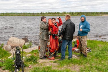 Destek ekibi, dalgıcın derin deniz çalışmalarına hazırlanmasına yardımcı olur..