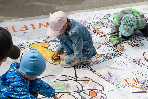 As crianças desenhar no chão com marcadores coloridos. Entretenimento ativo de crianças no festival . — Fotografia de Stock