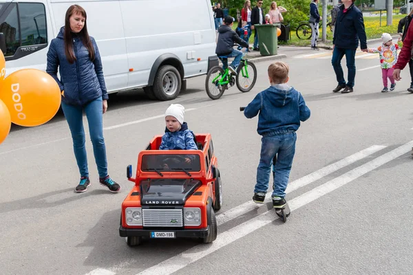 子供たちは祭りでおもちゃの車、スクーターや自転車に乗ります — ストック写真