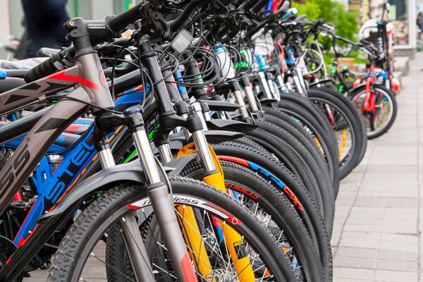 Многие велосипеды различных марок и цветов расположены в порядке рядов для продажи
.