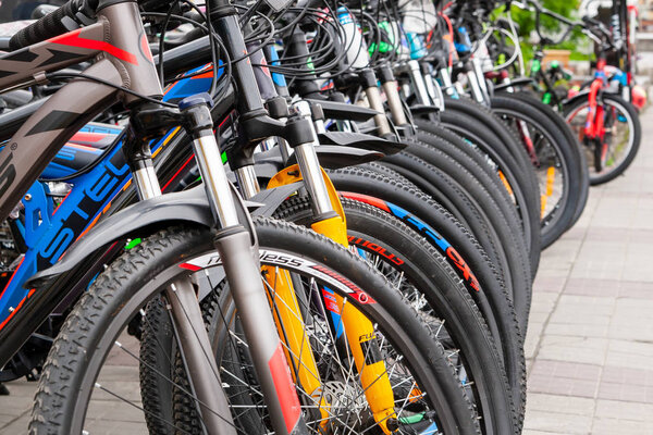 Многие велосипеды различных марок и цветов расположены в порядке рядов для продажи
.