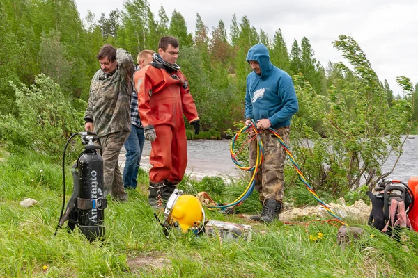 Dykare i våtdräkt på stranden. Utrustning för dykarbeten. — Stockfoto