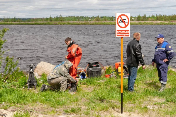 Varningsskylt på stranden av den tekniska reservoaren med inskriptionen-ingen dykning. I bakgrunden, dykning arbete. — Stockfoto
