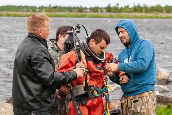 Podpůrný tým pomáhá potápěči připravit se na hlubokomořské práce. — Stock fotografie