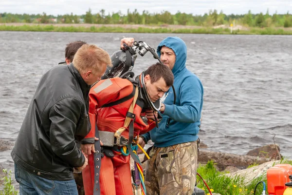 Destek ekibi, dalgıcın derin deniz çalışmalarına hazırlanmasına yardımcı olur..