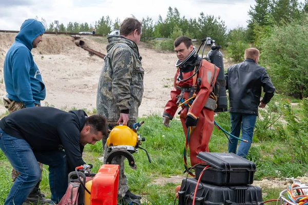 El equipo de apoyo ayuda al buceador a prepararse para el trabajo en alta mar . — Foto de Stock