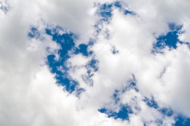 Beyaz bulutlar neredeyse mavi gökyüzünü doldurdu, aşağıdan görünümü.