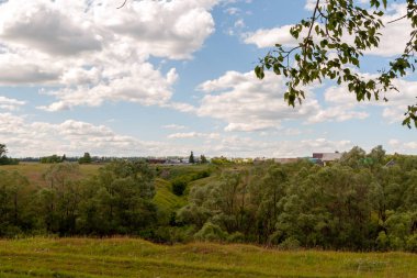 Kırsal peyzaj. Beyaz bulutlarla gökyüzünün altındaki Rus köyü