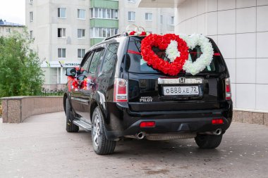 Düğün arabası. Parlak çiçeklerle süslenmiş siyah bir off-road arabası. 