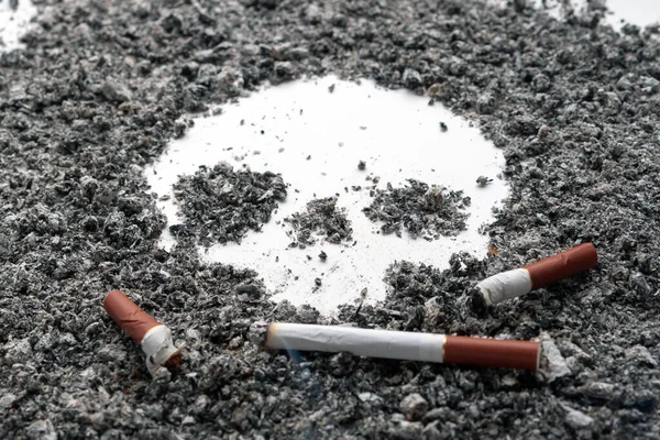 Un cigarrillo de fumar descansa sobre una ceniza de tabaco que parece una scu — Foto de Stock