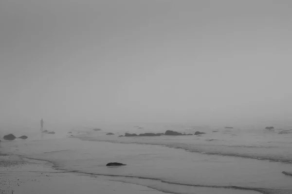 Одна Людина Пляжі Хвилями Піску Каменях Задньому Плані Монохромному — стокове фото