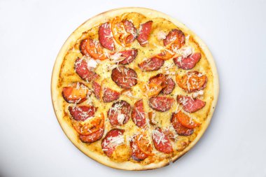 Domuz pastırması ve sosis dilimli ve peynirli yuvarlak pizza ahşap bir tahtanın üzerinde.