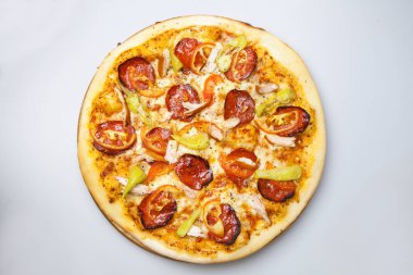 tavuk eti, peynir ve pastırma ile yuvarlak pizza pizzacı masada