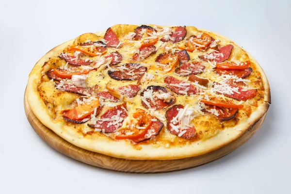 Pastırma ve sosis parçalı lezzetli pizza peynir serpiştirilir ve domateslerle süslenir.