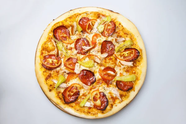 tavuk eti, peynir ve pastırma ile yuvarlak pizza pizzacı masada