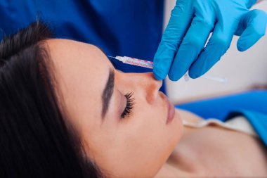 Doktor kıza kaşına bir iğne yapar.