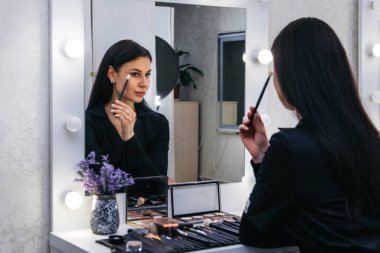 Makyajcı kuaförde makyaj yapıyor.