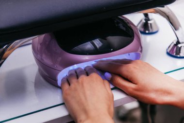 Kız ellerini ultraviyole lambaya koydu.