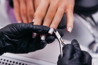 Manikürcü tel kesicilerle çalışır.