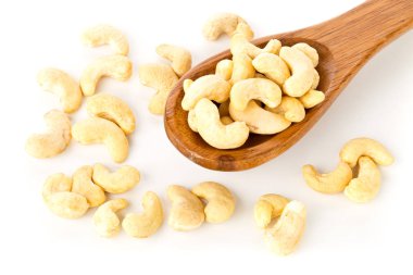 Tahta kaşık beyaz arka plan üzerinde ham, organik, Bütün kaşu fındık çekirdek yığını