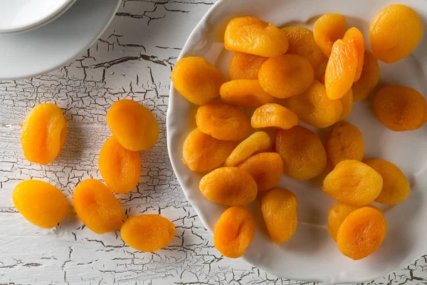 Fruta Albaricoques Secos Enteros Plato Blanco Sobre Fondo Rústico Mesa — Foto de Stock