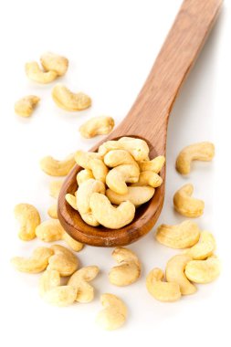 Tahta kaşık beyaz arka plan üzerinde ham, organik, Bütün kaşu fındık çekirdek yığını