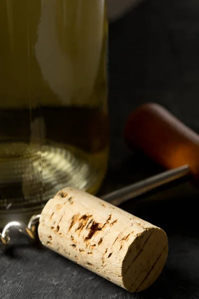 Brauner Naturweinkorken Mit Korkenzieher Und Flasche Weißwein Auf Dunklem Tischhintergrund — Stockfoto