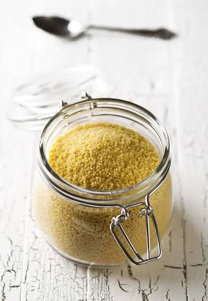 Heap Raw Uncooked Couscous Glass Jar White Wooden Table Background — Stock Photo, Image