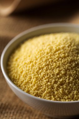 Çiğ, çiğ kuskus seçici odak çuval bezi zemin üzerine beyaz kase yığını