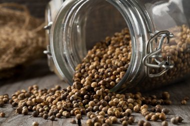 Ham, işlenmemiş organik kişniş veya kişniş tohumu cam koyu ahşap tablo